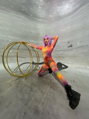 A dancer in a pink and yellow costume is performing a trick on a spinning wheel.
(girl, woman, people, exercise, sport, adult, fun, fashion, gymnastics, young, competition, one, fitness, motion, man, portrait, beach, balance, dancer, skill)