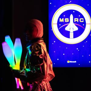 A young boy stands in front of a giant neon sign that reads.
(RC MS,music, performance, people, concert, stage, fashion, light, party, Christmas, portrait, art, woman, model, man, celebration, public show, winter, girl, band, moon)
