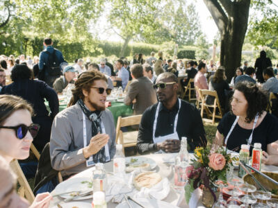 Guests enjoy a meal at the garden party.
(group, people, woman, many, festival, celebration, party, man, ceremony, restaurant, leader, adult, military, family, crowd, group together, religion, recreation, food, wine)